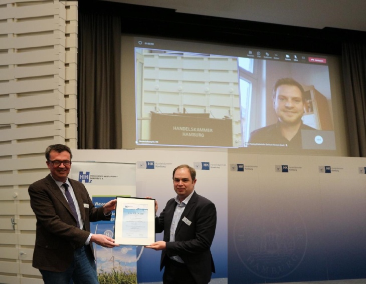 Michael Fröba (left) presents Julian Jepsen (right) with the certificate on behalf of Maximilian Passing (on screen).