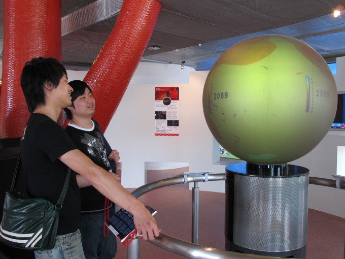 Visitors looking at a model of the earth