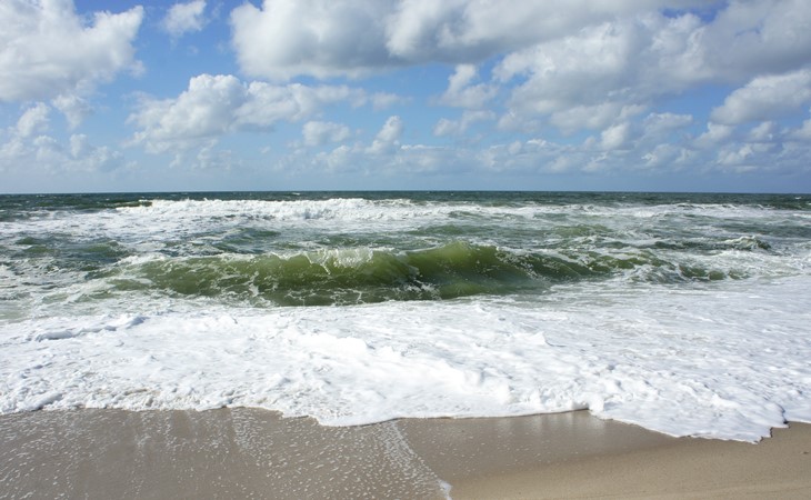 Wellen stranden im Sand
