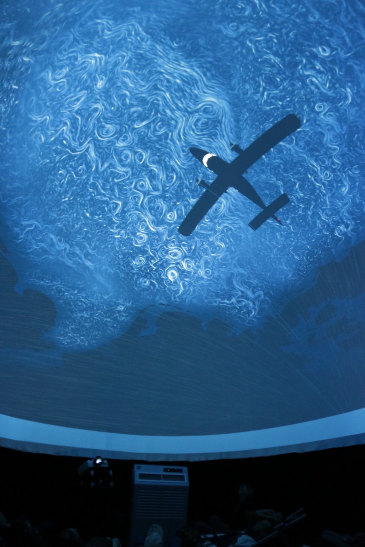 Ausschnitt aus dem Film "Uhrwerk Ozean" in der Mobilen Kuppel, man sieht ein Flugzeug über den Meereswirbeln