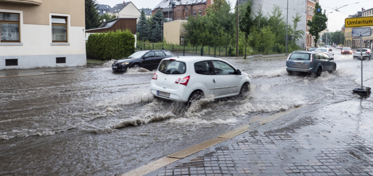 Starkregen auf den Straßen, Autos auf der Straße fahren durch Wasser