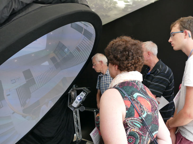 Besucher sehen sich den 360° Film über klimaneutrale Wasserstoff-Produktion an